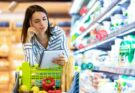 fiatal nő olvassa a bevásárlólistát a supermarketben